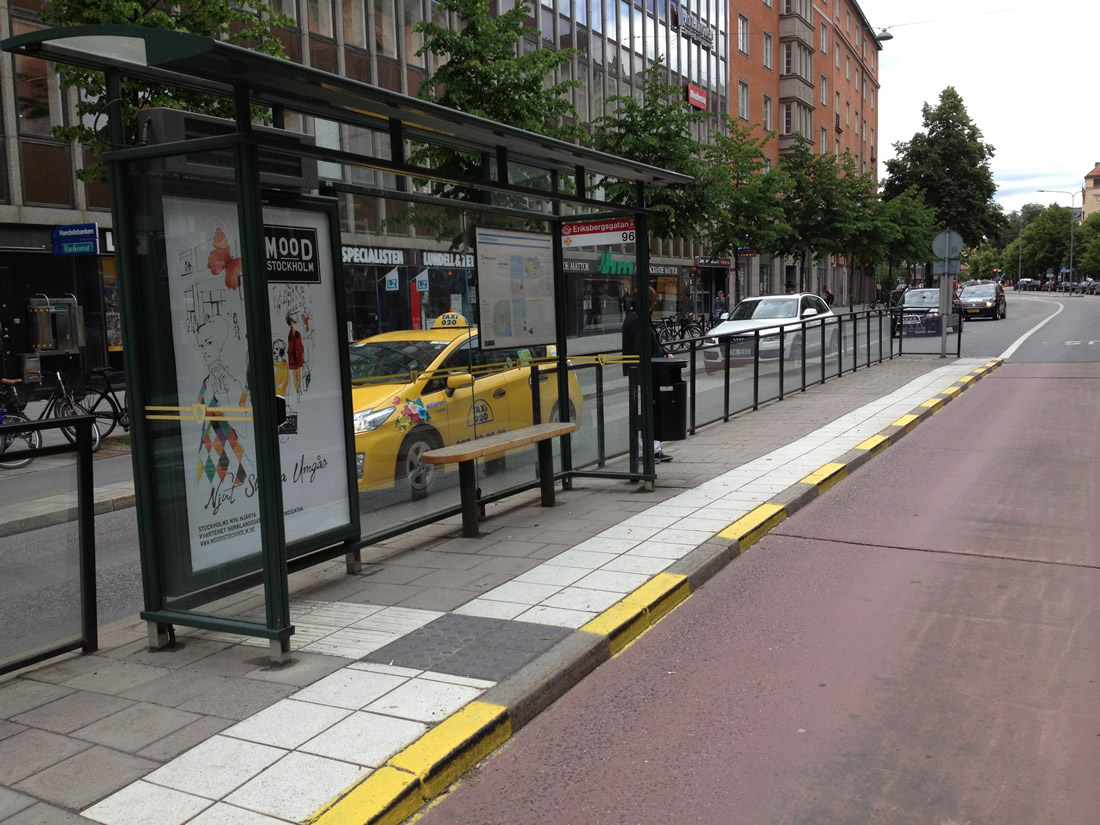 Autobusová zastávka s kontrastnými vodiacimi líniami a taktilným povrchom. Fotografia.