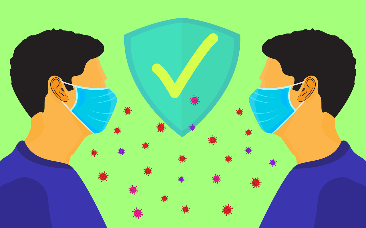 ilustrácia, dvaja muži oproti sebe, v rúškach, v strede naznačený symbol súhlasu, za dodržiavaný rozostup. Medzi nimi sú roztrúsené aj mikročastice vírusu, ale rúška a rozostup ich chránia