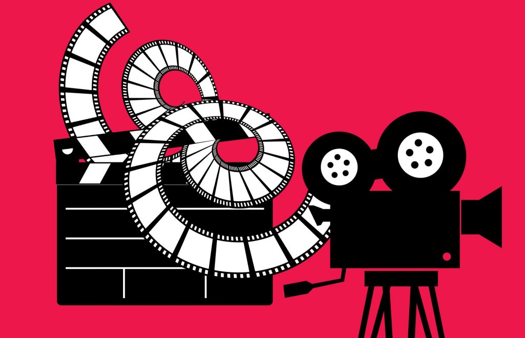 Na červenej ploche je čierno-biela ilustrácia, na ktorej sa nachádza filmárska kamera, filmová klapka a z kamery vychádza film.