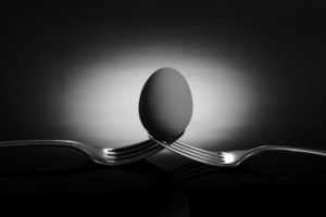 Na obrázku sa nachádzajú dve vidličky zakliesnené hrotmi do seba, vytvárajú sedielko, v ktorom je umiestnené vajíčko. Za ním sa nachádza svetlá plocha. Vytvárajú zaujímavý svetelný efekt.