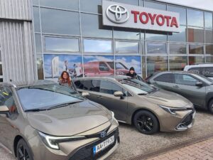 Pred predajňou TOYOTA sú dve autá a pri nich stoja Z. Egydová a S. Tóthová pripravené nastúpiť.