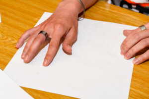 Tajomné bodky - ruka na papieri s braillovým písmom